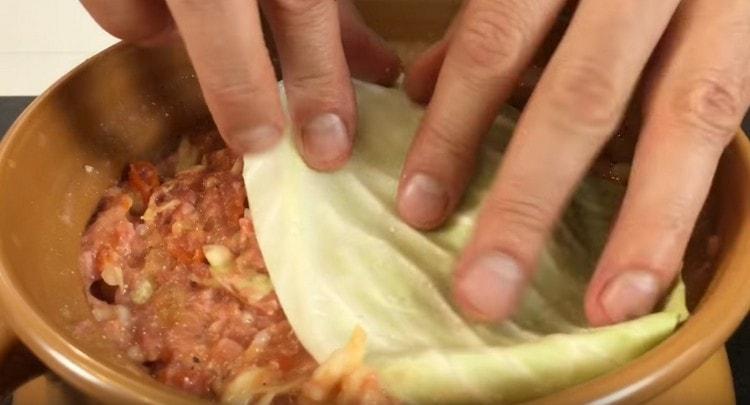 Όπως ένα καπάκι, καλύψτε το πιάτο με φύλλα λάχανου και στείλτε το στο φούρνο.