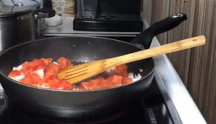 Į keptuvę su svogūnais įpilkite pomidorų.