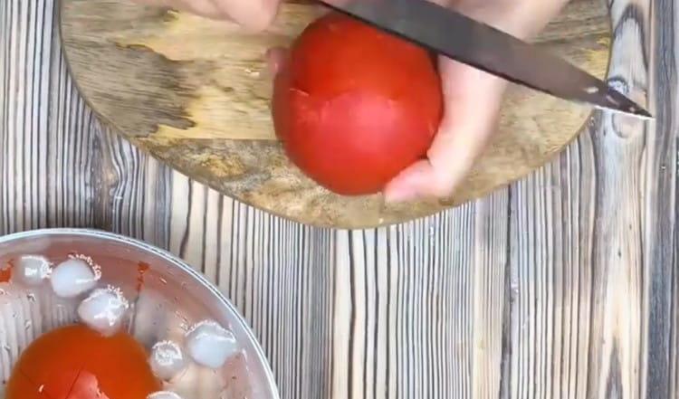 Μετατοπίζουμε τις ντομάτες μετά το βραστό νερό σε παγωμένο νερό και τις ξεφλουδίζουμε.