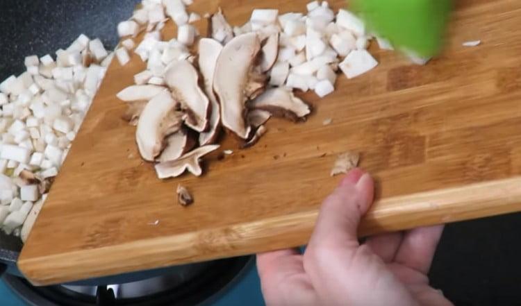 Taglia i funghi e aggiungi la padella all'aglio con le cipolle.