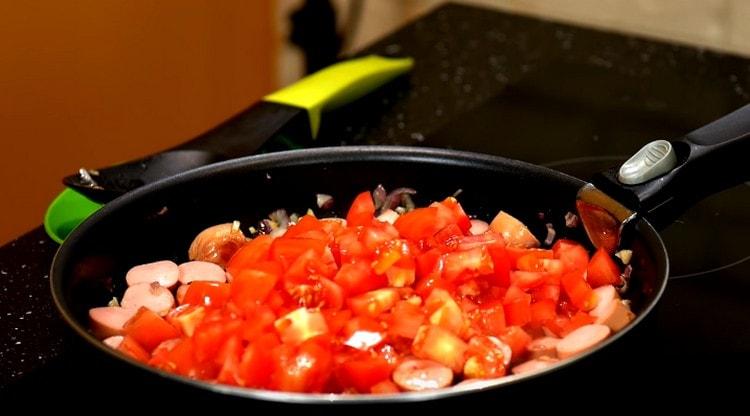 Προσθέστε τις φέτες ντομάτας στο ταψί.
