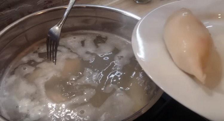 Prendiamo i calamari bolliti fuori dall'acqua e li mettiamo su un piatto per raffreddarli.