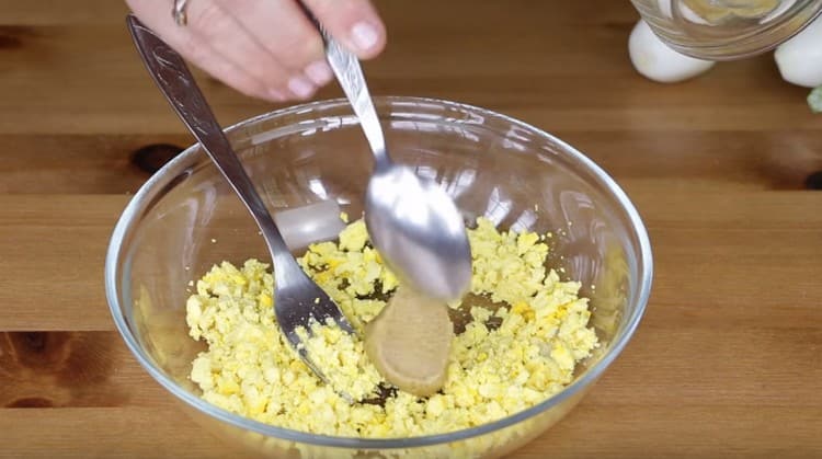 Τρίψτε τους κρόκους αυγού με μουστάρδα.