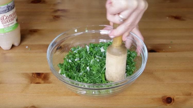 Fügen Sie Salz den Grüns hinzu und kneten Sie gut.