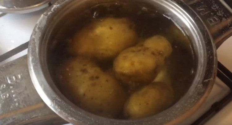 Kartoffeln in der Schale kochen.