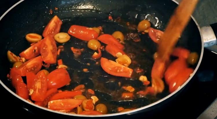 Tada sudėkite ančiuvius, pomidorus ir alyvuoges.