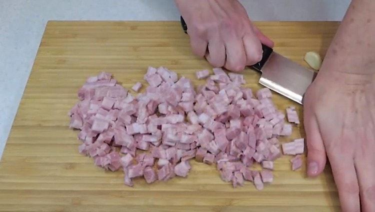 Schiaccia 2 spicchi d'aglio con un coltello.