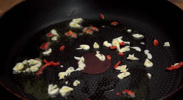 prima friggi l'aglio e il pepe in una padella con olio d'oliva.