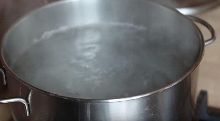In einer Pfanne Wasser zum Kochen von Nudeln zum Kochen bringen.