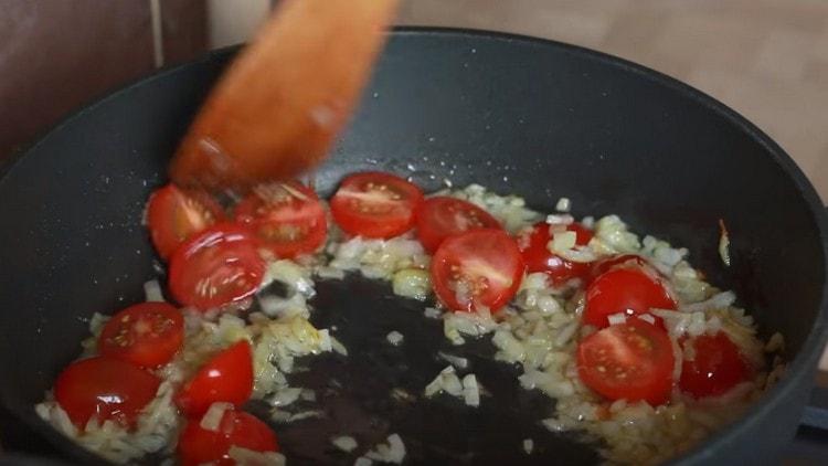 Fügen Sie Tomaten der Zwiebel hinzu.