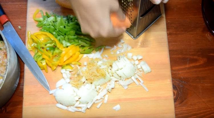 Trita le verdure per la salsa: cipolle, carote, peperoni, aglio.