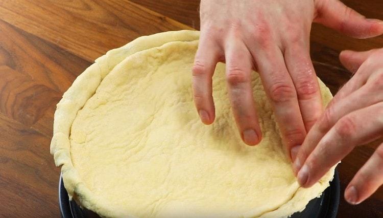 Coprire il ripieno con un secondo strato di pasta, pizzicare i bordi.