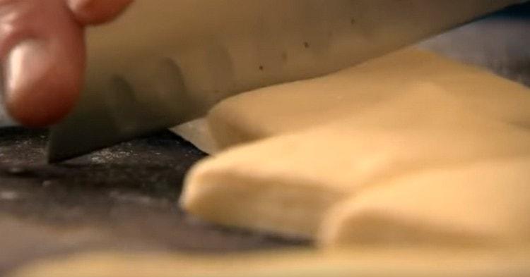 Stendere la pasta in uno spesso strato e tagliarla a rettangoli.