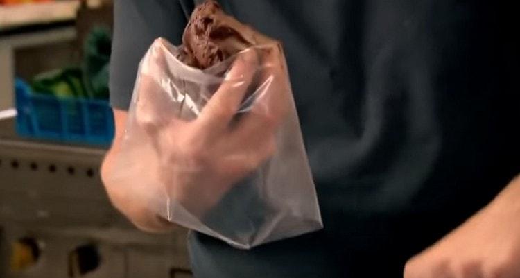 На ръка слагаме сладкарска торба с накрайник, в нея слагаме шоколадов пълнеж.