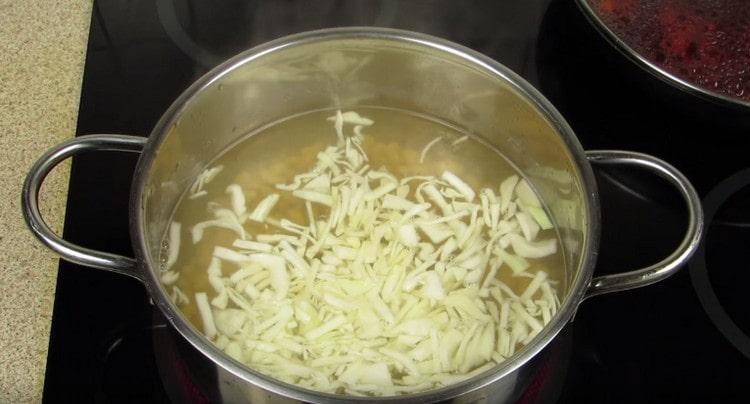 Σε μια κατσαρόλα με φασόλια, απλώστε το λάχανο.