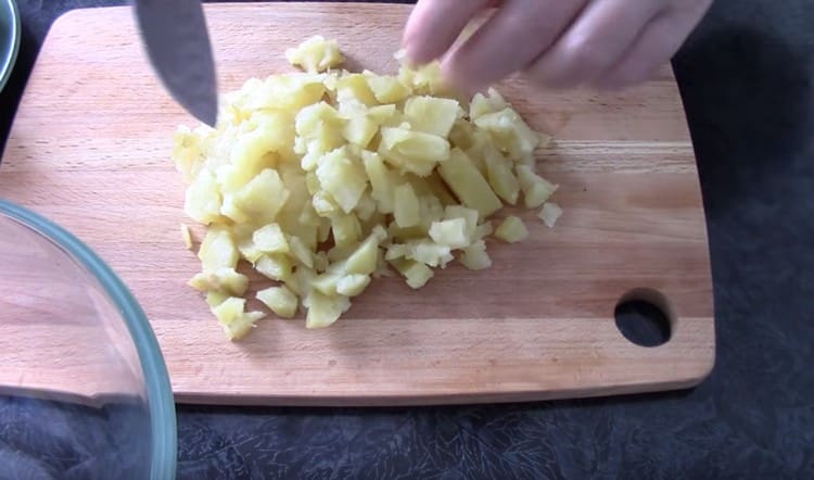 Gekochte Kartoffeln und Karotten würfeln.