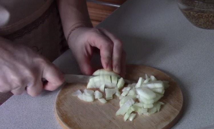 Zwiebeln und drei Möhren auf einer Reibe fein hacken.