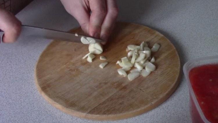 Taglia l'aglio a fettine sottili.