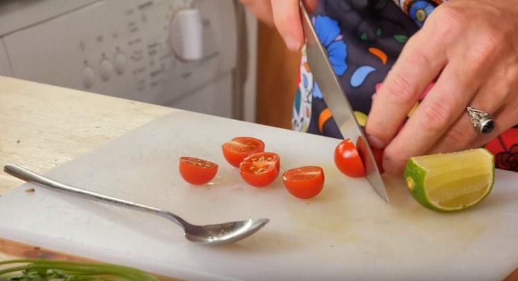 Vyšniniai pomidorai supjaustomi per pusę ir siunčiami į keptuvę.