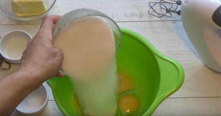 Į kiaušinius įpilkite cukraus.