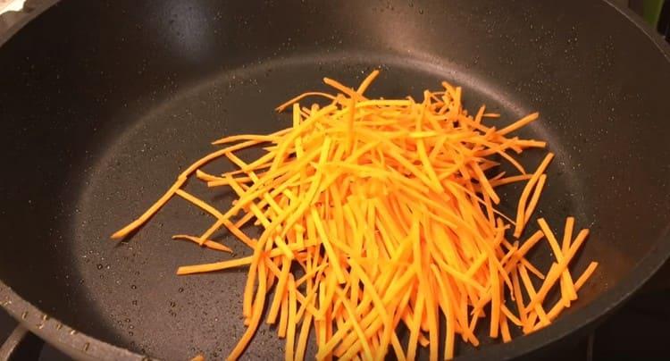 In Scheiben geschnittene oder auf einer koreanischen Reibe geriebene Karotten in einer trockenen Pfanne anbraten.