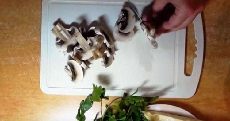 Tagliamo i funghi prataioli in piatti sottili.