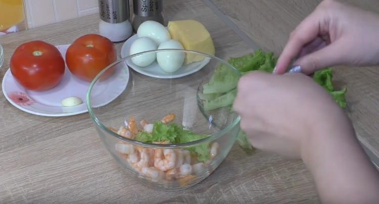 roztrhejte salát na kousky a přidejte do misky s krevetami.