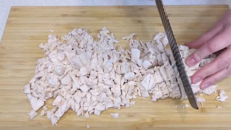نقطع شرائح الدجاج المسلوقة إلى قطع.