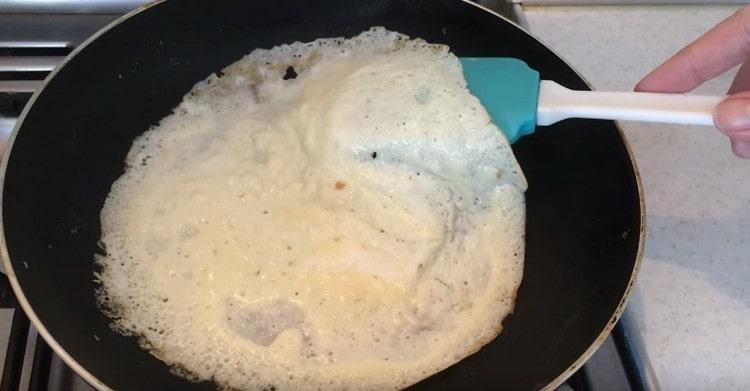 Főzzen vékony omlett palacsintát egy serpenyőben.