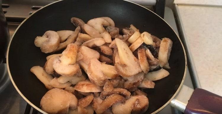 Ilagay ang mga frozen champignon sa kawali.