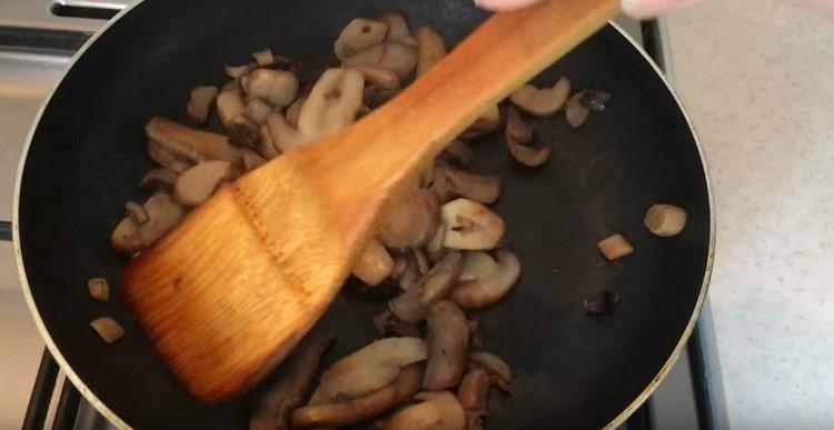 Vypusťte tekutinu vytvořenou na pánvi a smažte houby, dokud nezměknou.