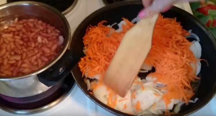 τηγανίζουμε τα καρότα και τα κρεμμύδια μέχρι να στραγγίξουν σε μια κατσαρόλα.