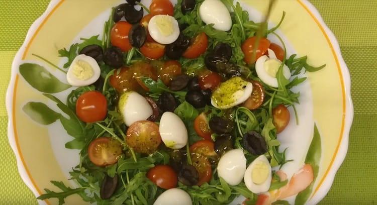 Přidejte rukolou vejce, olivy, rajčata a dresing.