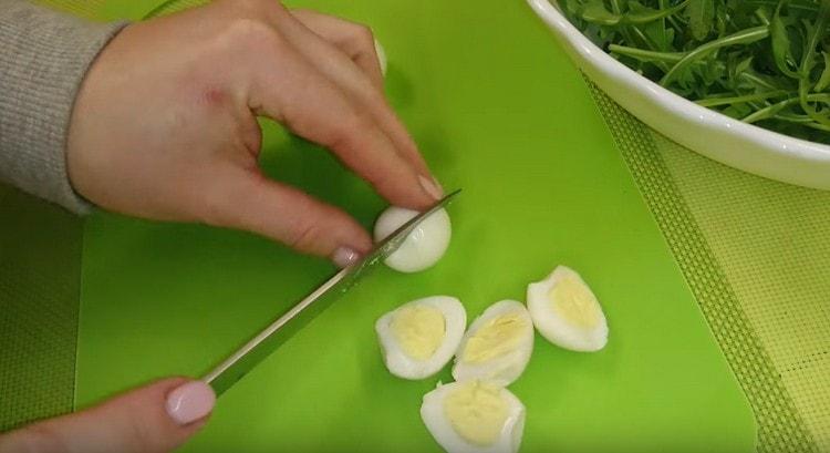 Κόψτε τα αυγά ορτυκιών στο μισό.