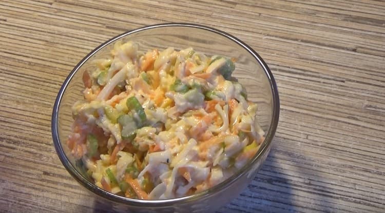 Condire l'insalata con sedano, condimento all'aglio, mescolare e il piatto è pronto.