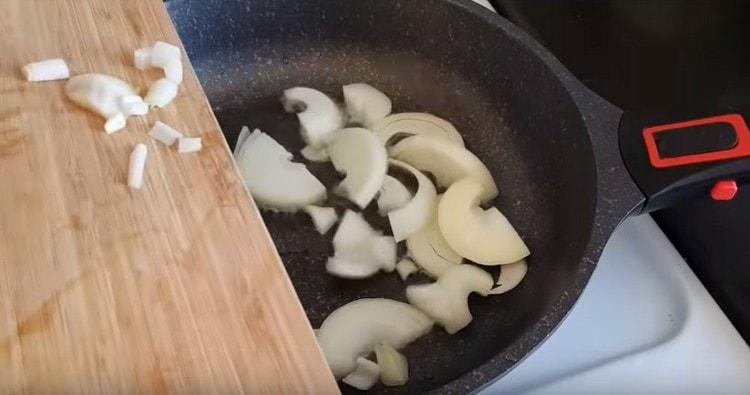 Ρίξτε το φυτικό έλαιο στο τηγάνι και απλώστε τα κρεμμύδια.