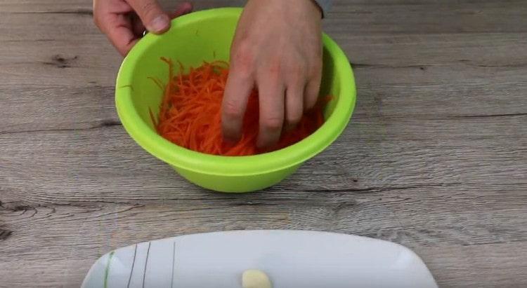 Strofina le carote su una grattugia.