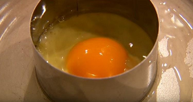 Friggere un uovo in un'altra padella in un anello da pasticceria.