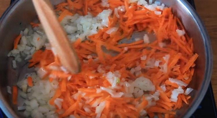 Φροντίστε τα καρότα με κρεμμύδια σε ένα τηγάνι με φυτικό λάδι.
