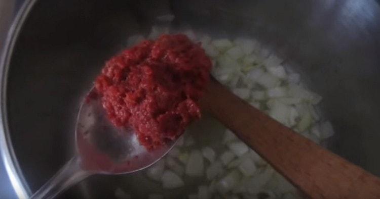 Į keptuvėje esantį svogūną įpilkite pomidorų pastos.