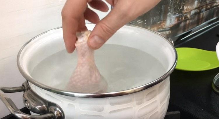 Hähnchenschenkel in kochendem Wasser verteilen.