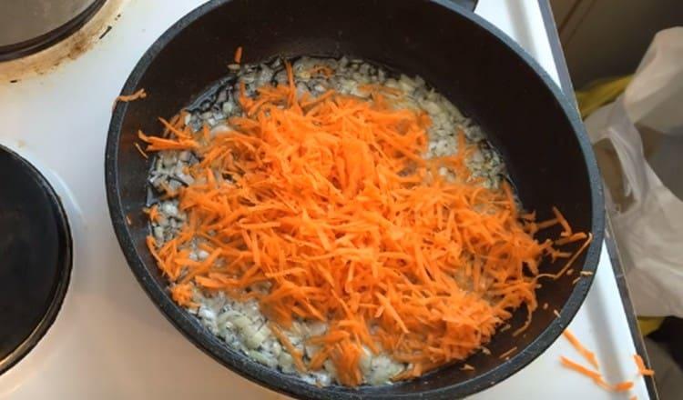 Fügen Sie die geriebene Karotte der Zwiebel hinzu und bereiten Sie das Braten vor.