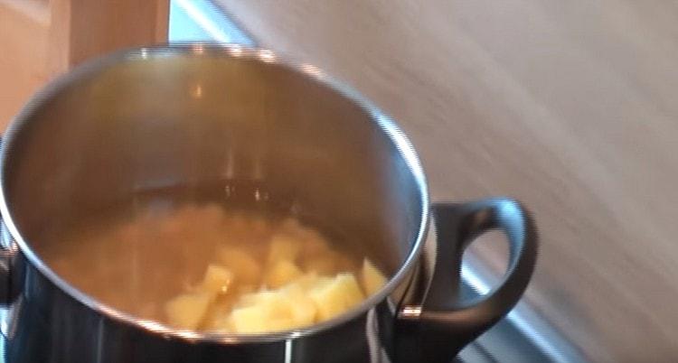 Kartoffeln mit Bohnen in den Topf geben.
