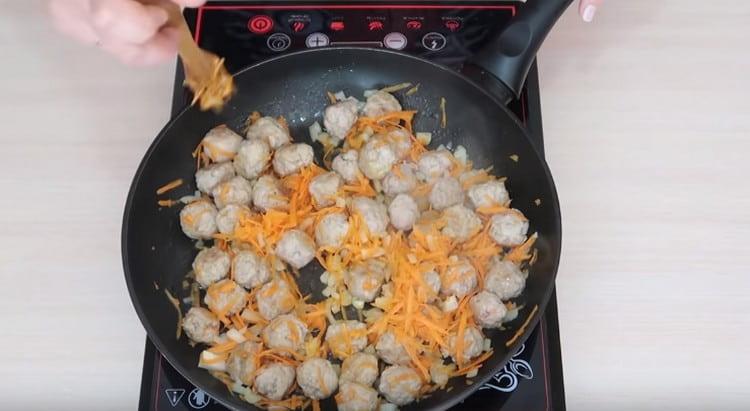 Gehackte Karotten und Zwiebeln zu den Frikadellen in der Pfanne geben.