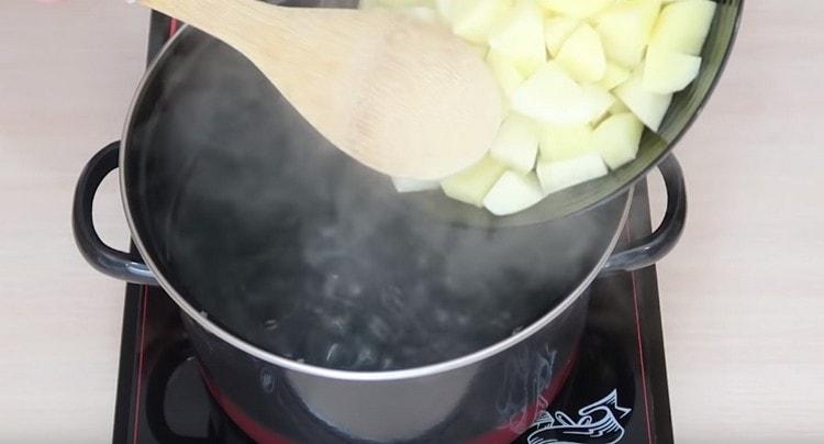 Wir legen in kochendes Wasser geschnittene Kartoffeln.