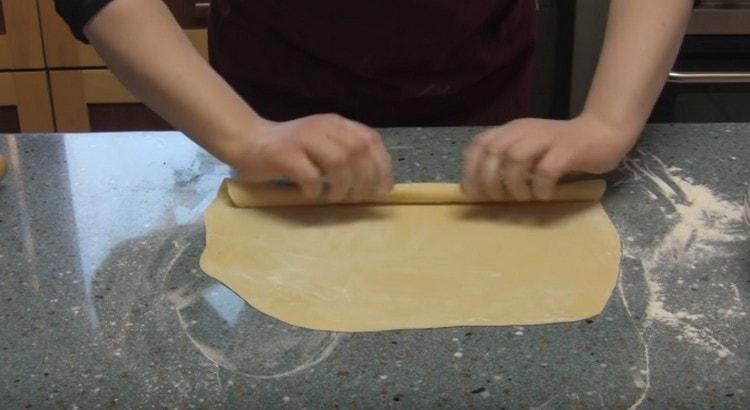 Поръсете ситно нарязаното тесто с брашно и го разточете с хлабаво руло.