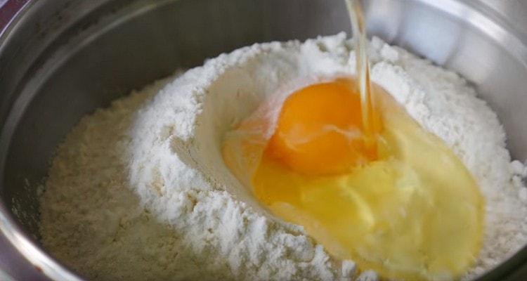 Depressziót készítünk a lisztben, és megverjük a tojást.