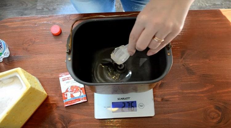 Gießen Sie Wasser in einen Eimer einer Brotmaschine, fügen Sie Salz und Pflanzenöl hinzu.