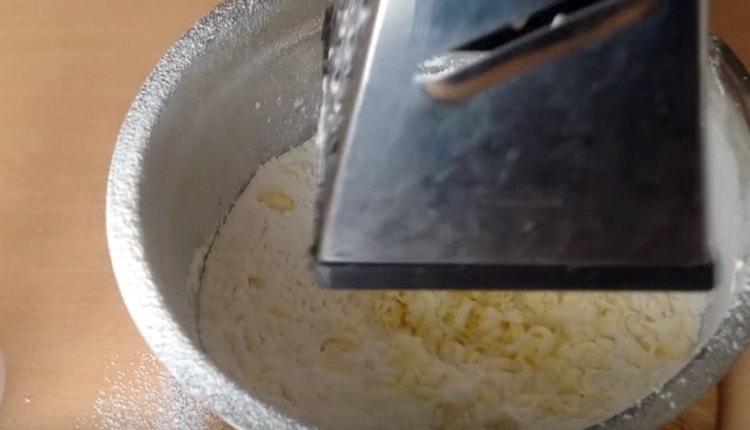 Nastrouhejte studené máslo v mouce.