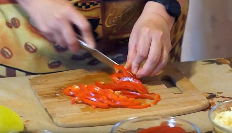 Tritare il peperone a strisce.